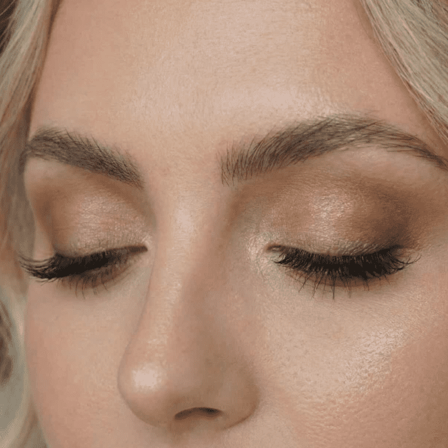 Nærbillede af øjenmakeup: Elegante jordfarver og definerede bryn til brudemakeup.