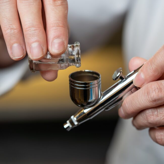 Nærbillede i Serenity Salon, der forbereder udstyr til påføring af serum som en del af en iltbehandling mod hårtab.